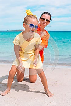 Beautiful mother and daughter at the beach enjoying summer vacation.