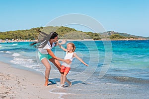 Beautiful mother and daughter at the beach enjoying summer vacation.