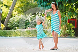 Beautiful mother and daughter at the beach enjoying summer vacation.