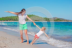 Beautiful mother and daughter at the beach enjoying summer vacation.