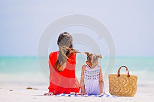 Beautiful mother and daughter at the beach enjoying summer vacation.