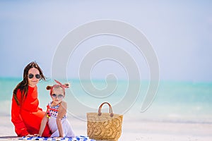 Beautiful mother and daughter at the beach enjoying summer vacation.