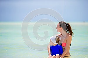 Beautiful mother and daughter at the beach enjoying summer vacation.