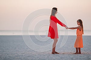 Beautiful mother and daughter at the beach enjoying summer vacation.