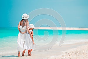 Beautiful mother and daughter at the beach enjoying summer vacation.