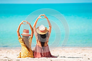 Beautiful mother and daughter at the beach enjoying summer vacation.