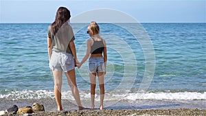 Beautiful mother and daughter on the beach enjoying summer vacation