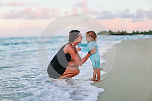 Beautiful mother and daughter at Caribbean beach enjoying summer vacation.