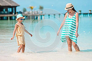 Beautiful mother and daughter at Caribbean beach enjoying summer vacation.