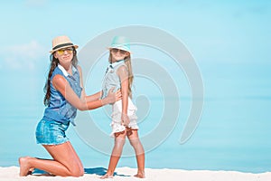 Beautiful mother and daughter at Caribbean beach enjoying summer vacation.