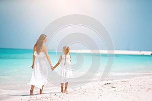 Beautiful mother and daughter at Caribbean beach enjoying summer vacation.