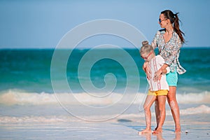 Beautiful mother and daughter at Caribbean beach enjoying summer vacation.