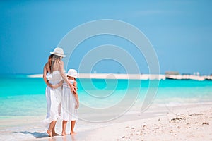 Beautiful mother and daughter at Caribbean beach enjoying summer vacation.