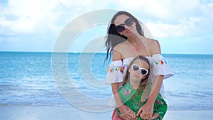 Beautiful mother and daughter on Caribbean beach. Portrait of family on summer vacation