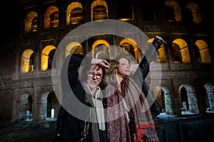 Beautiful mother and daughter enjoying themselves in the evening at the Roman Colosseum