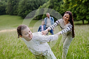 Beautiful mother with daughter, playing at meadow, running, having fun. Concept of Mother's Day and maternal love.