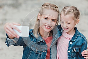 beautiful mother and daughter taking selfie