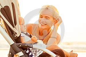 Beautiful mother and her cute child walking before going to sleep on the beach