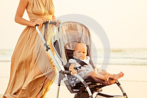 Beautiful mother and her cute child walking before going to sleep on the beach