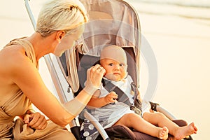 Beautiful mother and her cute child walking before going to sleep on the beach