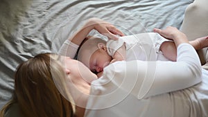 Beautiful mother and her cute little baby are sleeping at home,hugging in bed. Child safety and protection, co-sleeping