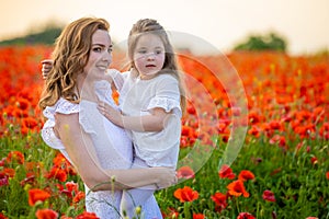 Beautiful mother and her daughter in spring poppy flower field, Czech republic