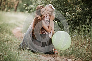 Beautiful Mother And her little daughter outdoors. Nature. Outdoor Portrait of happy family. Happy Mother`s Day Joy