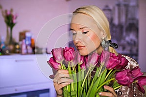 Beautiful mother hold a bouquet of white tulips on 8th of march. Flowers in woman`s hand