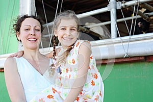 Beautiful mother and little daughter smile near