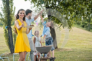 Beautiful mother showing thumbs up while spending quality time with family