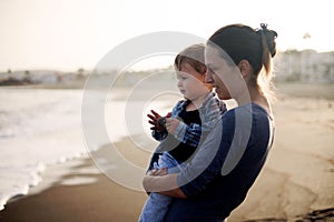 Beautiful mother and son playing on the beach