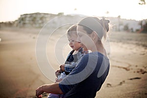 Beautiful mother and son playing on the beach