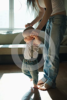 Beautiful mother teaches baby to walk