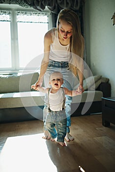 Beautiful mother teaches baby to walk