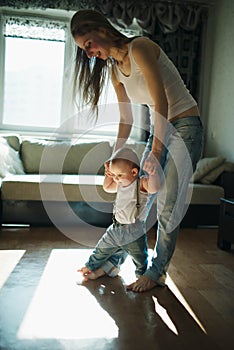 Beautiful mother teaches baby to walk