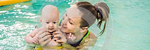 Beautiful mother teaching cute baby girl how to swim in a swimming pool. Child having fun in water with mom BANNER, LONG