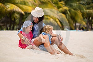 Beautiful mother and two kids enjoying beach vacation.