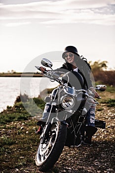 Beautiful motorcycle brunette woman with a classic motorcycle c