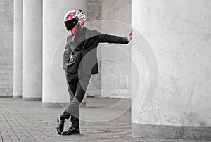 Beautiful motorcyclist in black suit and helmet with black visor