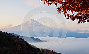 Beautiful Mount Fuji with sea of mist and red maple leaves in th