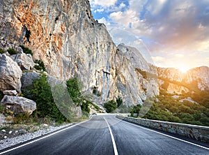 Beautiful mountain asphalt road with rocks, blue sky at sunset