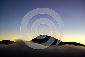 Beautiful mountain landscape with hazy peaks and foggy valley at sunset