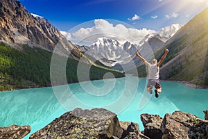 Beautiful mountain landscape with lake and jumping man