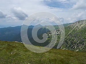 Beautiful mountain landscape with lush green grass, meadow and bare mountain peaks on ridge Western Tatras mountains