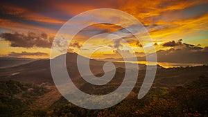 Beautiful mountain landscape during sunrise. Hills, Batur volcano and lake. Scenic panoramic view. Colorful sky with clouds. Foggy