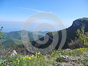 Beautiful mountain landscape with top view of a distant forest covered slopes. Sea far below on the horizon. Crimean mountains