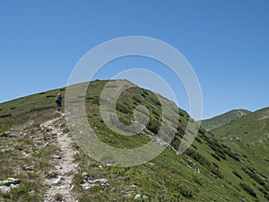Krásná horská krajina Západních Tater nebo Roháčů s mužským turistou s batohem turistickou stezkou na hřebeni
