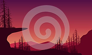 Beautiful mountain panorama at dusk with the silhouette of dry trees around it. Vector illustration