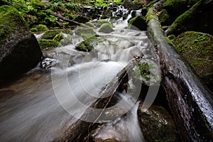 Beautiful mountain rainforest waterfall with fast flowing water and rocks, long exposure.