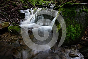 Beautiful mountain rainforest waterfall with fast flowing water and rocks, long exposure.